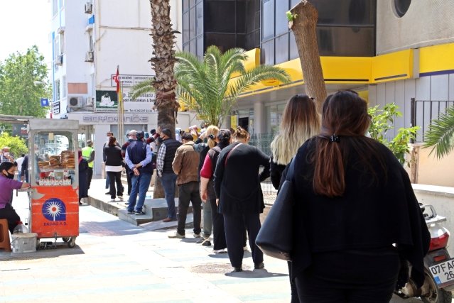 Kuyrukta beklemekten yorulan vatandaşlar yerlere oturup bekledi